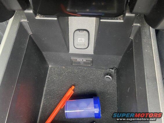 Car center console with AUX input and 12V power outlet.