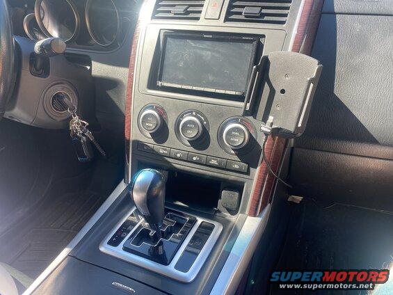 Interior of a 2009 Mazda CX-9, showing gear shifter, climate controls, stereo, and phone mount.