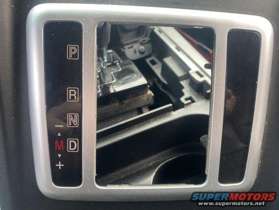 Close-up of car gear shifter display showing P, R, N, M, D, and +/-.
