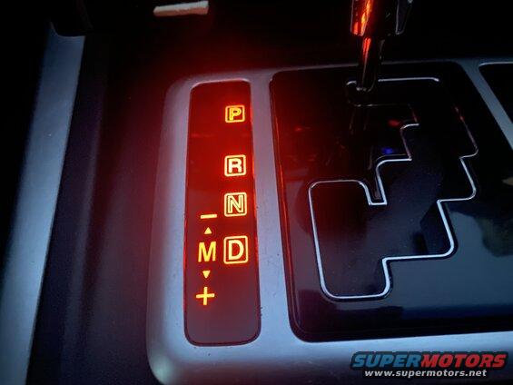 Illuminated gear selector for an automatic transmission showing P, R, N, M, D.