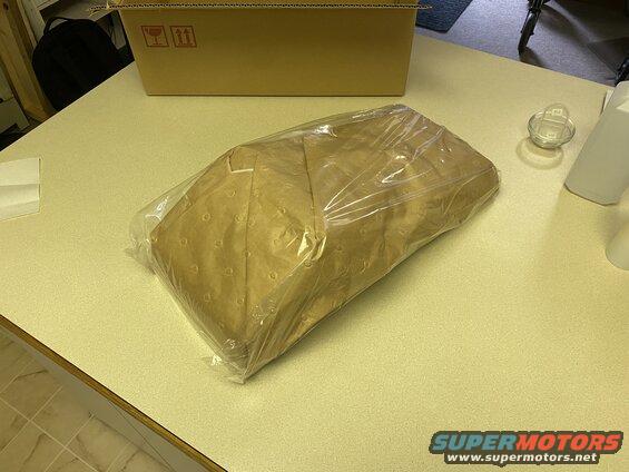 Package wrapped in brown paper and plastic on a countertop.
