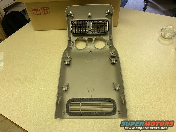 Gray interior dashboard trim with air vents and circular cutouts