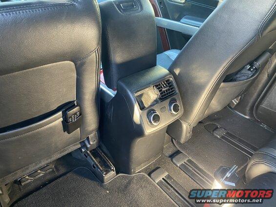 Interior rear view of a vehicle showing center console, seats, umbrella, and remote.