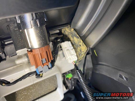 Close-up of car interior showing electrical connectors and wiring.