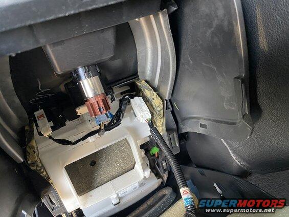 Interior view of car dashboard wiring and components, including connectors and cigarette lighter.
