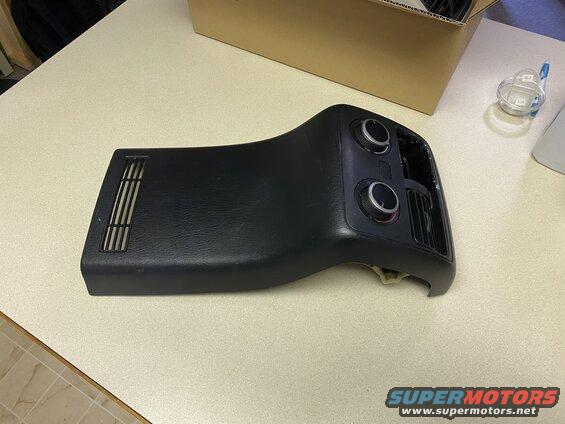 Black automotive dashboard trim with knobs and vents