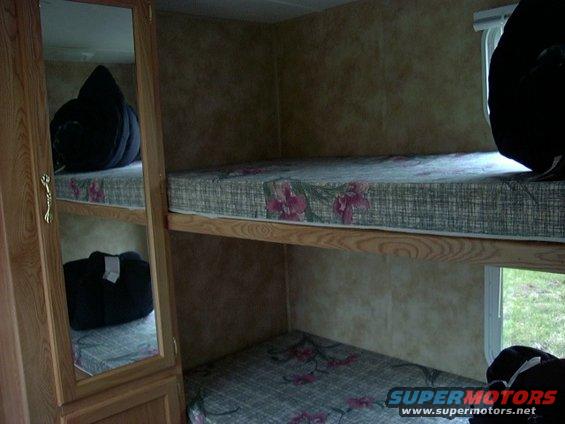 Interior view of bunk beds in a camper with floral patterned mattresses