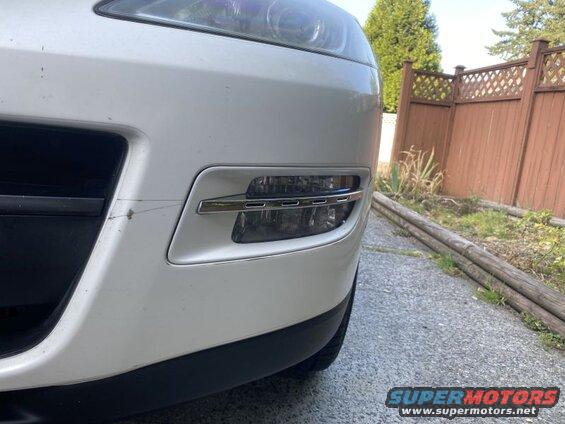 White SUV bumper with fog light and chrome trim, showing a scratch.