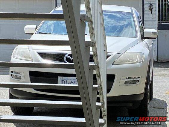 White 2009 Mazda CX-9 SUV front view, behind metal gate, license plate JD1 55