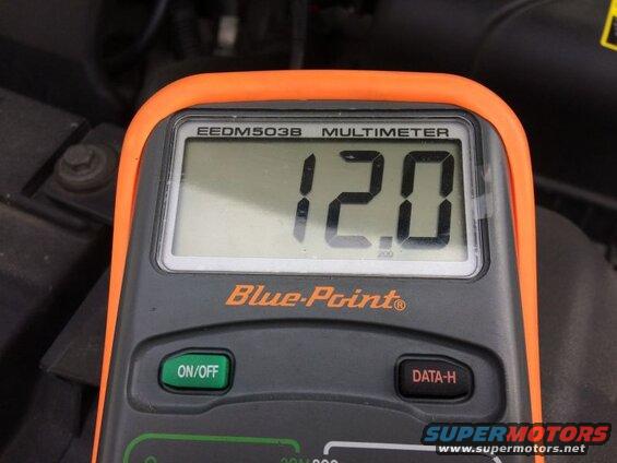 Digital multimeter showing 12.0 volts