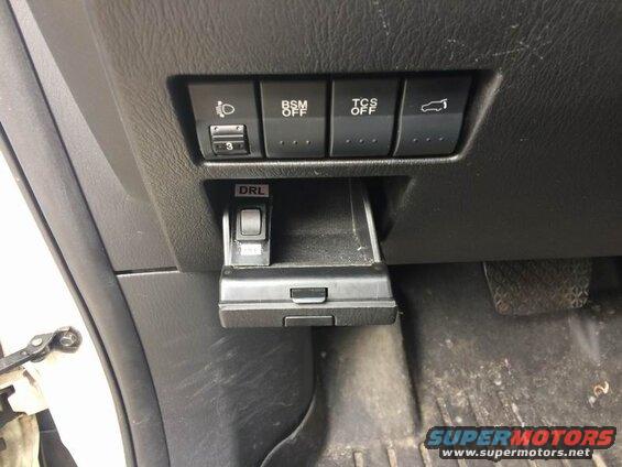 Interior dashboard of a vehicle with multiple buttons and a DRL switch.