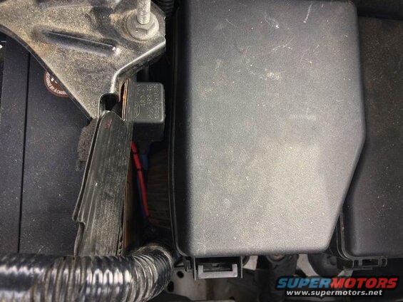 Automotive relay with part number 460 398-16 near car battery and fuse box.