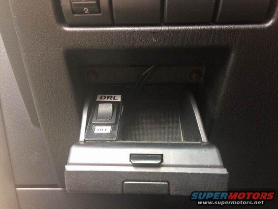 Close-up of a DRL switch in a car dashboard.