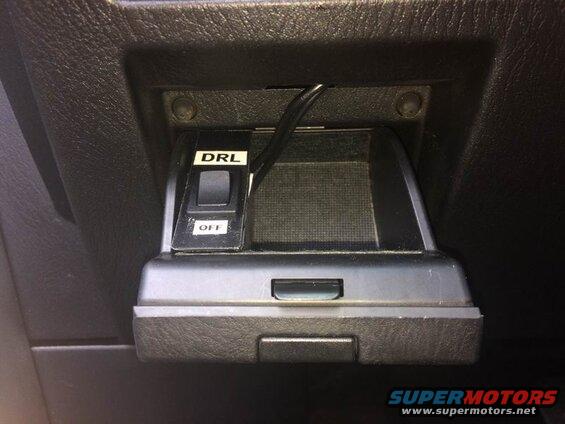 DRL and OFF switches on a black dashboard panel with a wire.