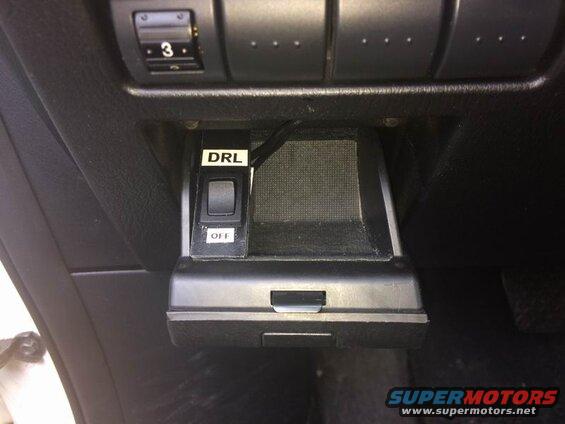 Close-up of car dashboard with DRL switch and compartment