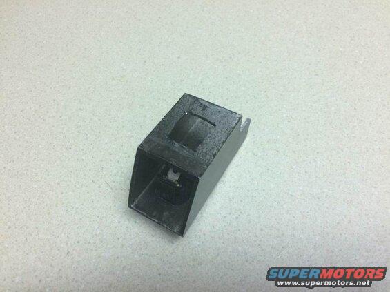 Black plastic automotive part on a speckled countertop.
