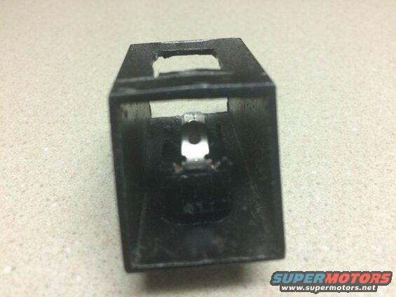 Black metal component with internal silver mechanism and copper wires.