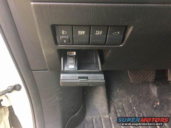 Interior dashboard of a car with buttons for lights, BSM, TCS, trunk, and DRL.