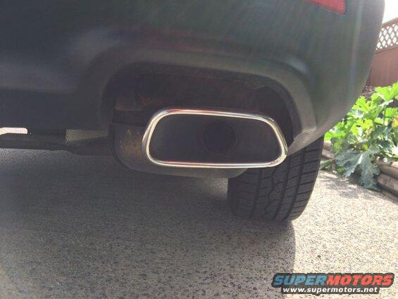 Close-up of a car's exhaust pipe with chrome trim.