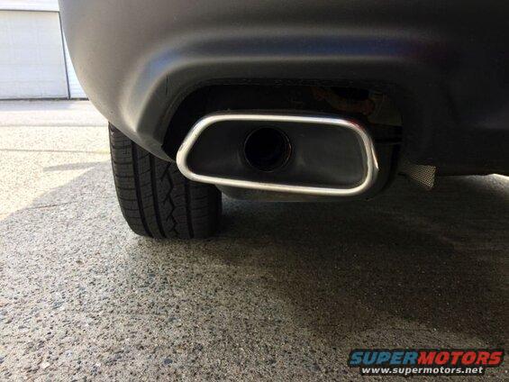 Black SUV rear bumper with chrome-trimmed oval exhaust pipe.