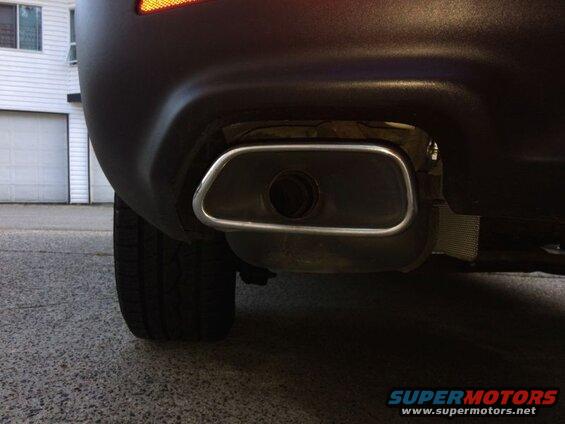 Rear view of a car's exhaust pipe with chrome trim.