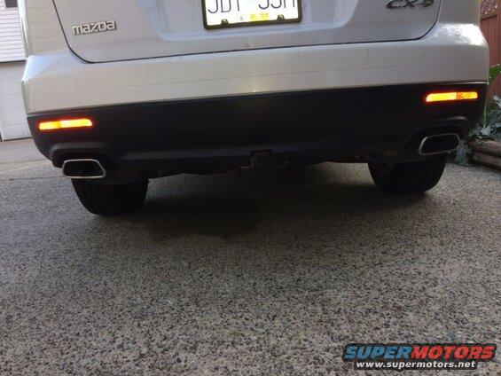 Rear view of a white 2009 Mazda CX-9 SUV showing dual exhaust and red reflectors.
