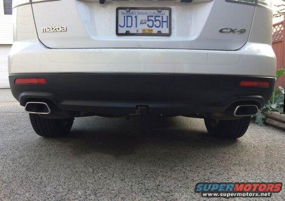 Rear view of a white 2009 Mazda CX-9 with license plate JD1 55H and dual exhaust pipes.