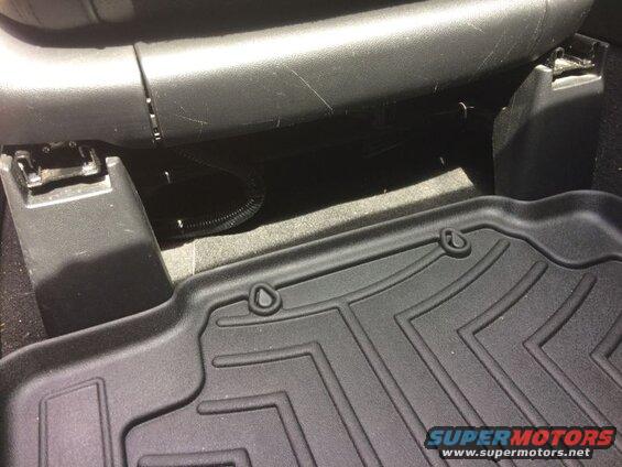 Black WeatherTech floor mat in vehicle footwell under seat