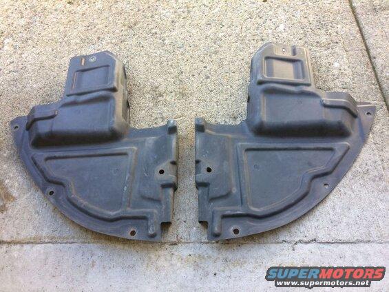 Two black plastic underbody splash shields on concrete