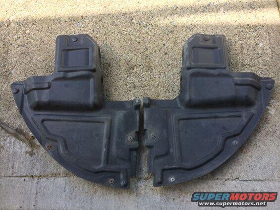 Two black plastic underbody splash shields for a vehicle.