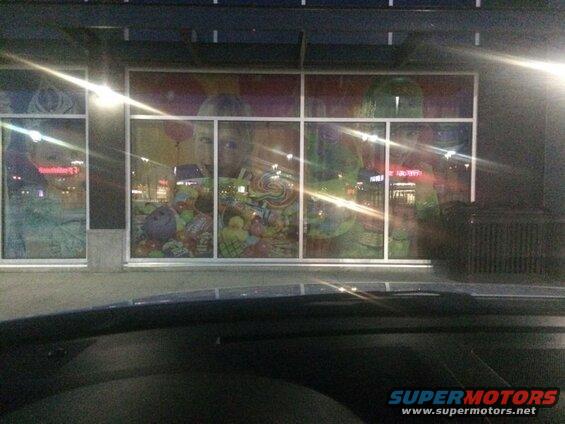 Storefront window display with candy and toy decorations.