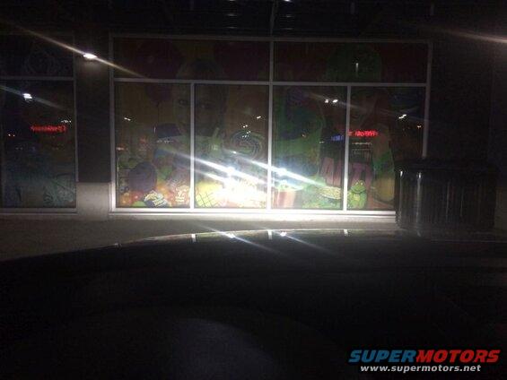 Storefront window display with candy and cartoon graphics at night.