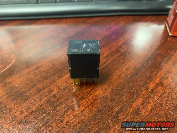 Black automotive relay with text '89723 2314 JAPAN UM46 67 730 ACM33221 M19'