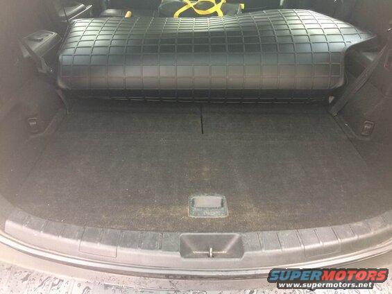 Rear cargo area of an SUV with a black rubber floor mat