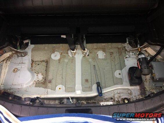Vehicle cargo area with floor exposed, showing tools.