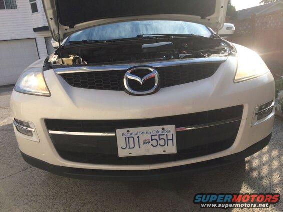 White 2009 Mazda CX-9 front view, hood open, headlights on, BC license plate JD1-55H