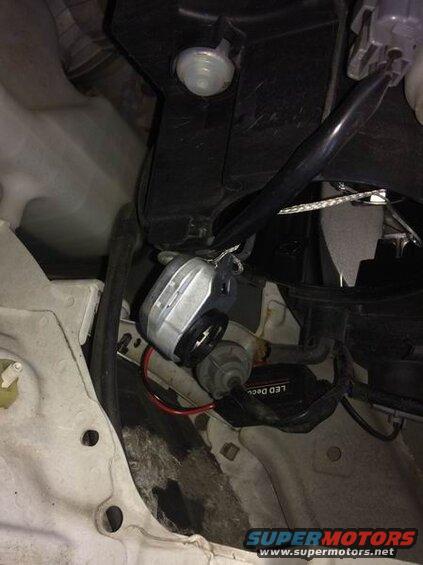 Aftermarket LED headlight bulb and ballast installed in a 2009 Mazda CX-9 engine bay.
