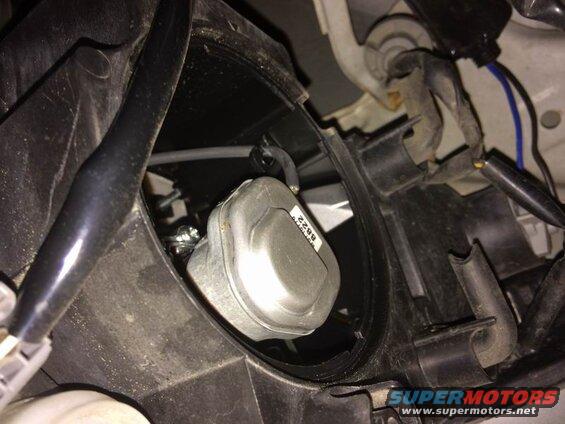 Left side: the low beam housing is right next to the fender. Twist off the weather cap, twist off the electrical connector, unclip the two bulb retainer arms (push in each arm so it can move outwards), pivot the retainer downwards and pull the bulb out.