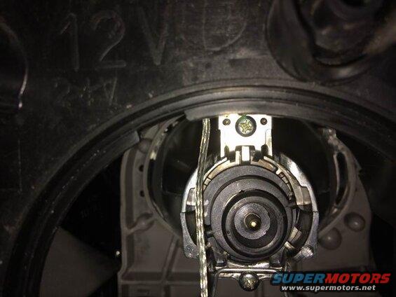 Left side: the low beam housing is right next to the fender. Twist off the weather cap, twist off the electrical connector, unclip the two bulb retainer arms (push in each arm so it can move outwards), pivot the retainer downwards and pull the bulb out.
