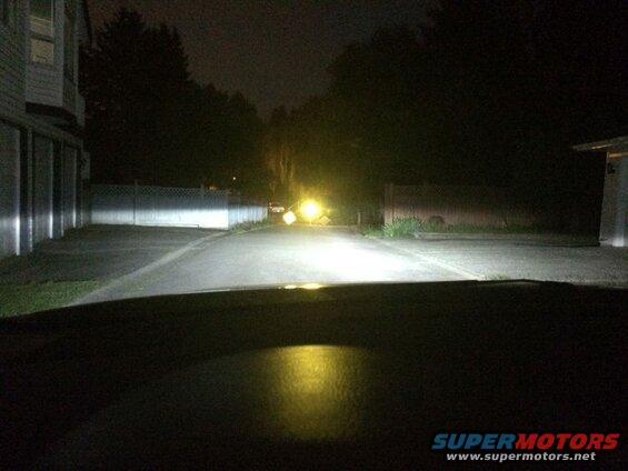 2009 Mazda CX-9 headlights on at night, illuminating a driveway.