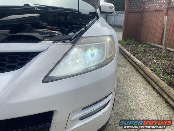 White 2009 Mazda CX-9 front passenger side, hood open, parked on driveway.