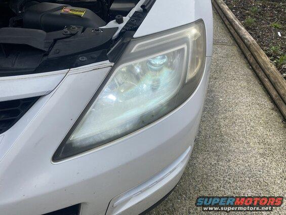 White Mazda CX-9 front right headlight assembly with open hood