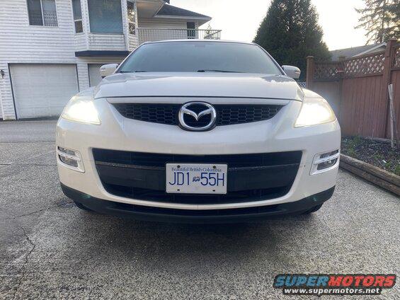 White 2009 Mazda CX-9 SUV front view with headlights on and BC license plate JD1 55H