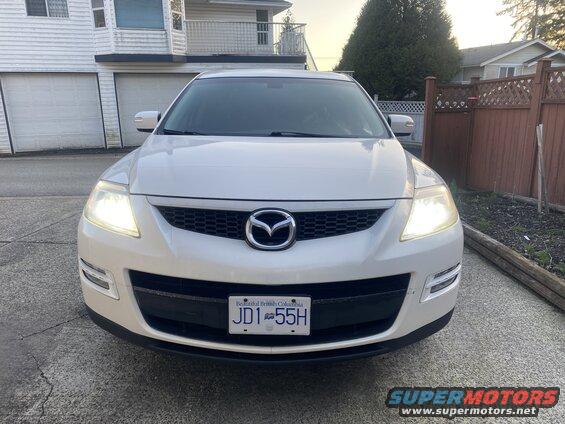 White 2009 Mazda CX-9 SUV front view with headlights on and BC license plate JD1 55H