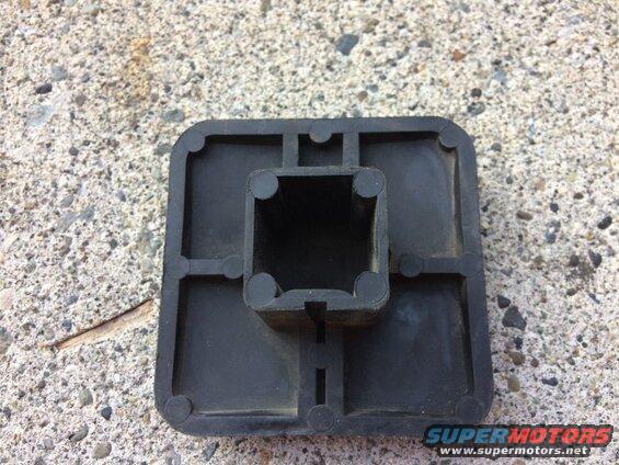 Black plastic square foot cap with hollow square opening on concrete