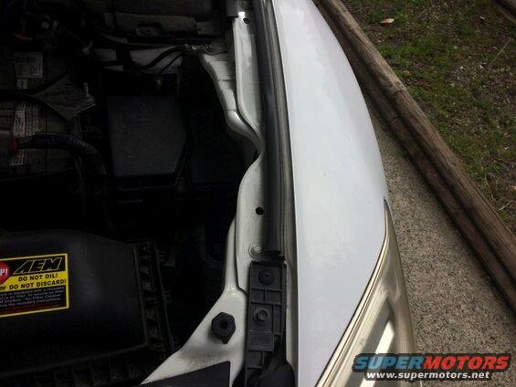 White vehicle engine bay with AEM air filter and battery.