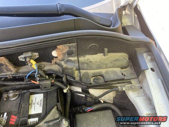 2009 Mazda CX-9 engine bay with battery and wiring, covered in dust.