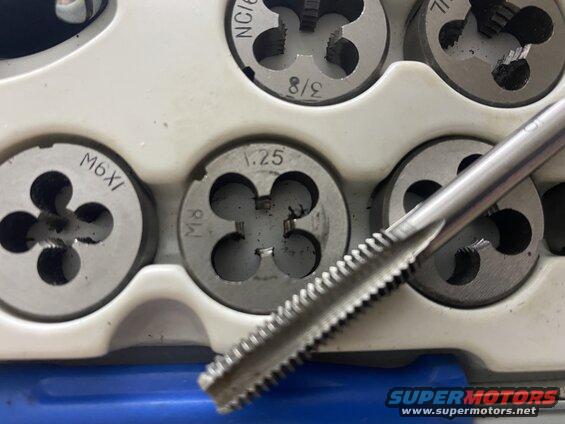 Close-up of threading dies and tap tool with size markings