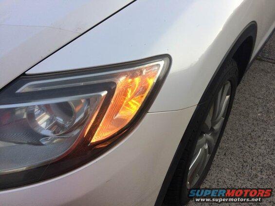 White SUV passenger side headlight and wheel