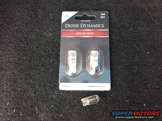 Diode Dynamics HP5 LED bulbs package with one bulb out of package on carpet.